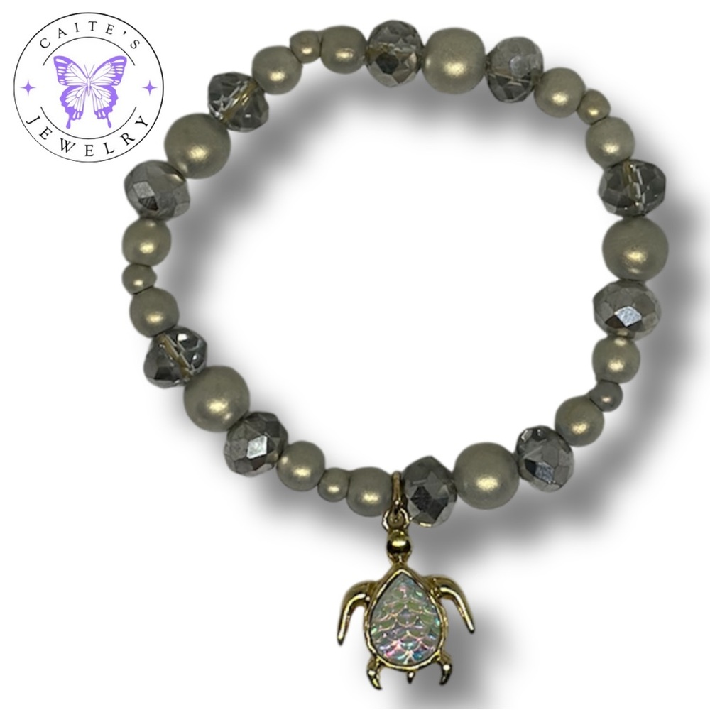 Handmade Gold Elastic Bracelet with Iridescent Grey Beads and a Turtle Charm
